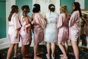 Bride and bridesmaids with their back to the camera in bride and bridesmaids robes